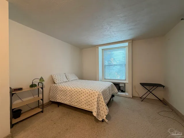 a bedroom with a bed chair and window