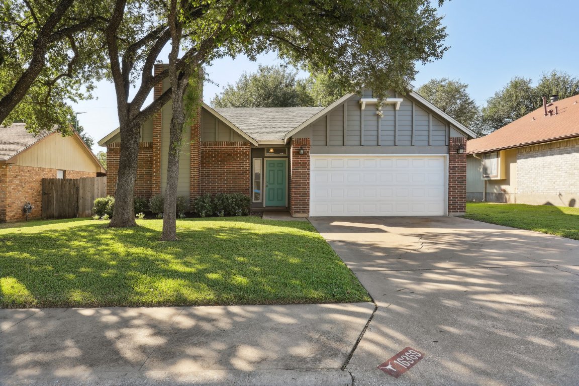 View of front facade with brick siding, concrete driveway, and an attached garage