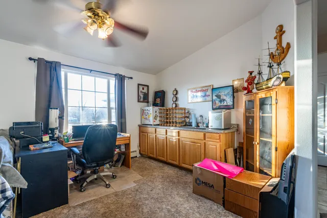 a view of a workspace with furniture and a window