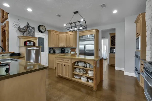 a kitchen with stainless steel appliances granite countertop a refrigerator a stove and a sink