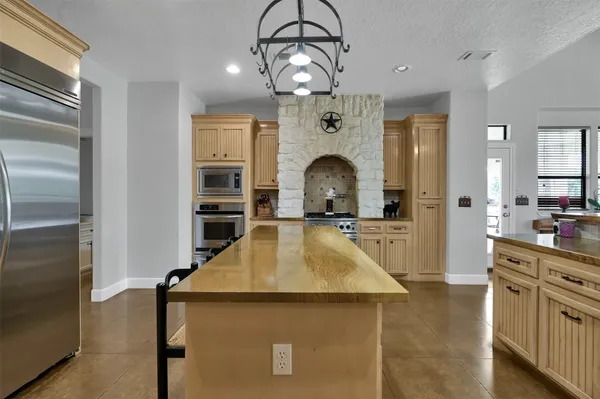 a kitchen with kitchen island a counter top space appliances and cabinets
