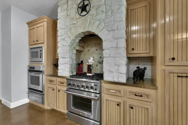 a kitchen with a stove and white cabinets