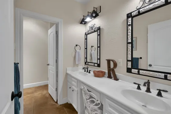 a bathroom with double vanity sink a vanity and a mirror