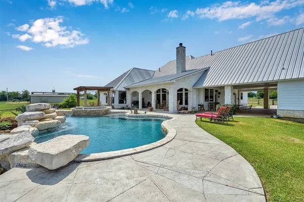 a front view of a house with swimming pool yard fire pit and outdoor seating