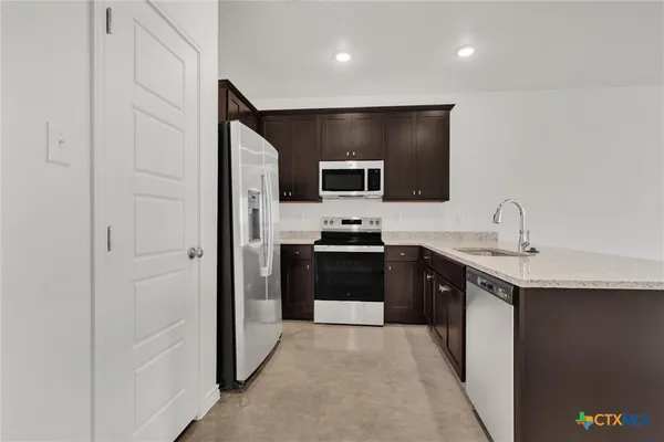 a large kitchen with a sink and stainless steel appliances