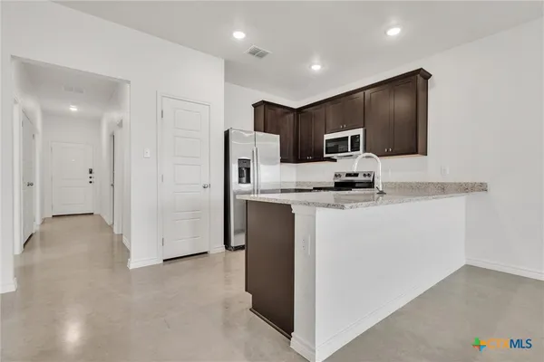 a kitchen with stainless steel appliances granite countertop a refrigerator stove a sink and dishwasher