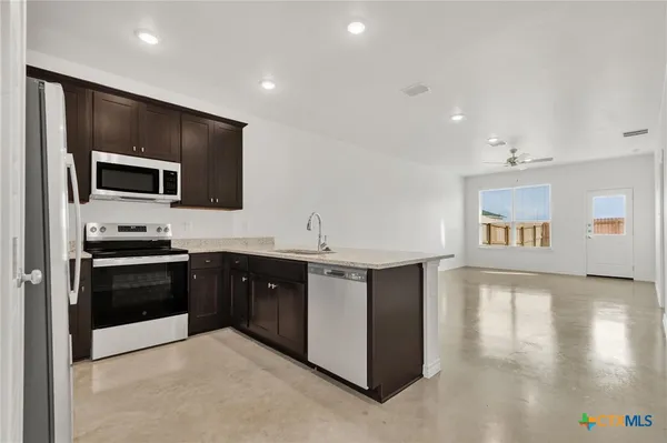 a kitchen with stainless steel appliances granite countertop a stove and a sink