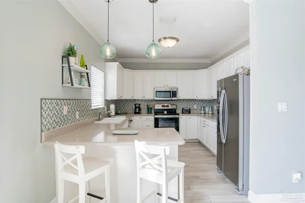 a kitchen with stainless steel appliances granite countertop a refrigerator a sink dishwasher a stove and a refrigerator with wooden floor