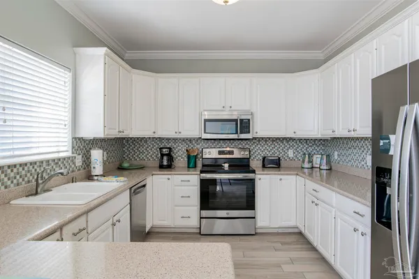 a kitchen with white cabinets stainless steel appliances and sink