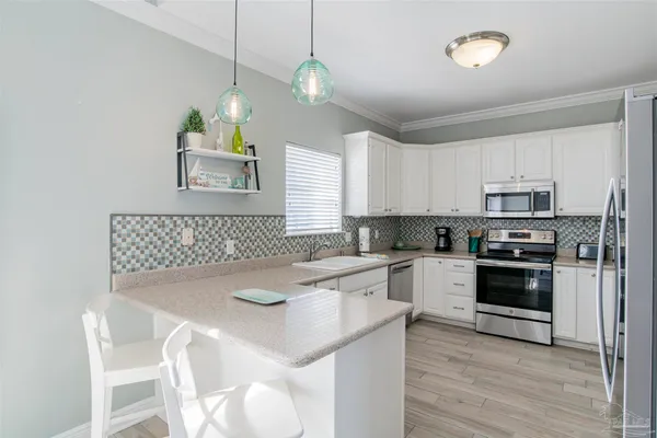 a kitchen with appliances a sink and cabinets