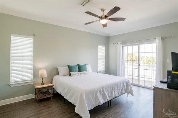 a bedroom with a large bed a chandelier and a window