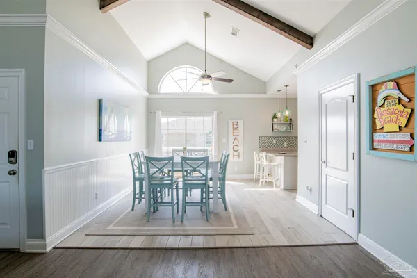 a view of a dining room with furniture a chandelier and wooden floor