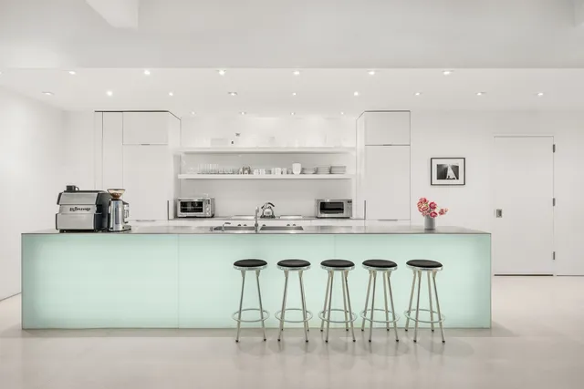 a large white kitchen with lots of counter space a sink and appliances