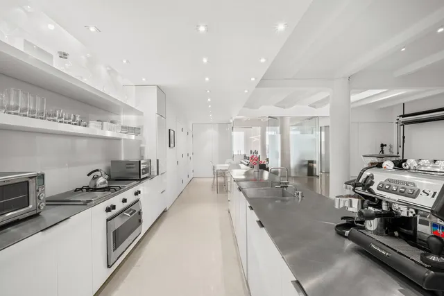 a kitchen with stainless steel appliances granite countertop a table chairs in it and white cabinets