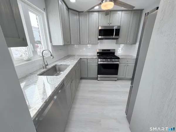 a kitchen with granite countertop a stove and a sink