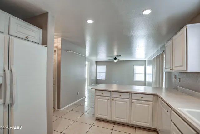 a kitchen with kitchen island white cabinets and white stainless steel appliances