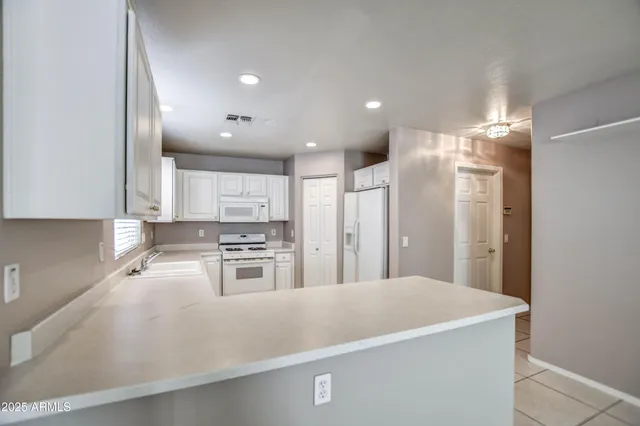 a kitchen with stainless steel appliances granite countertop a refrigerator a stove and a sink