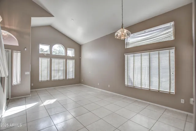 a view of an empty room with a window and chandelier