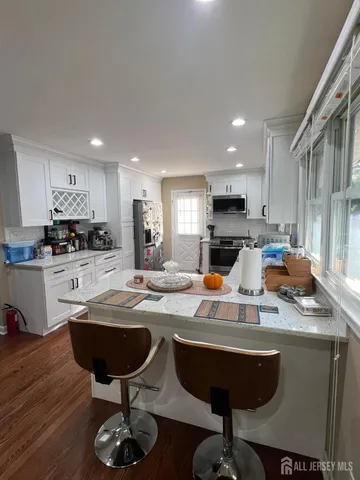 a kitchen with stainless steel appliances granite countertop a sink refrigerator and cabinets