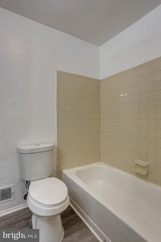 a bathroom with a white toilet sitting next to a white sink and vanity