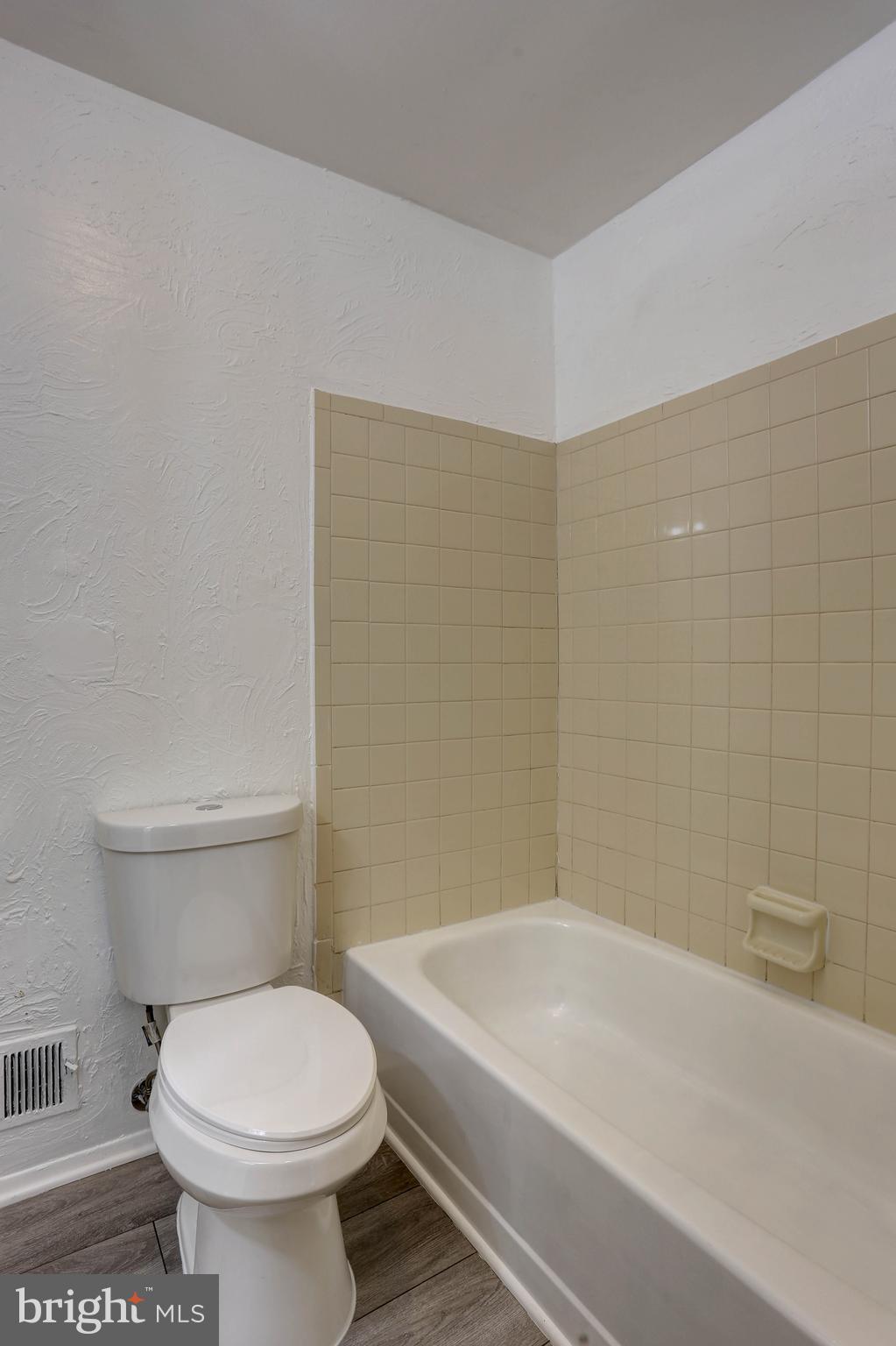 410 South Washington Street Baltimore, MD 21231 - Photo 12 of 29 a bathroom with a white toilet sitting next to a white sink and vanity