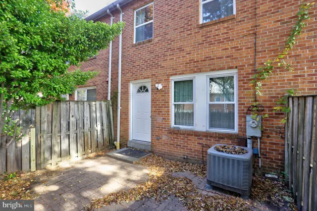 a view of house with backyard outdoor seating and wooden fence