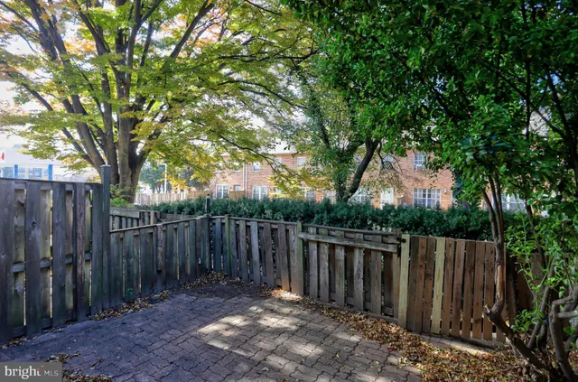a view of deck with wooden fence and large trees