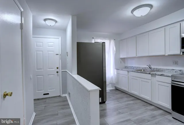 a kitchen with cabinets and wooden floor