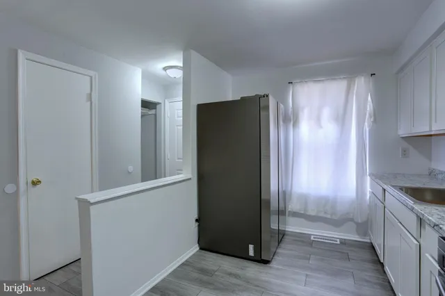 a view of a kitchen with a refrigerator and cabinets