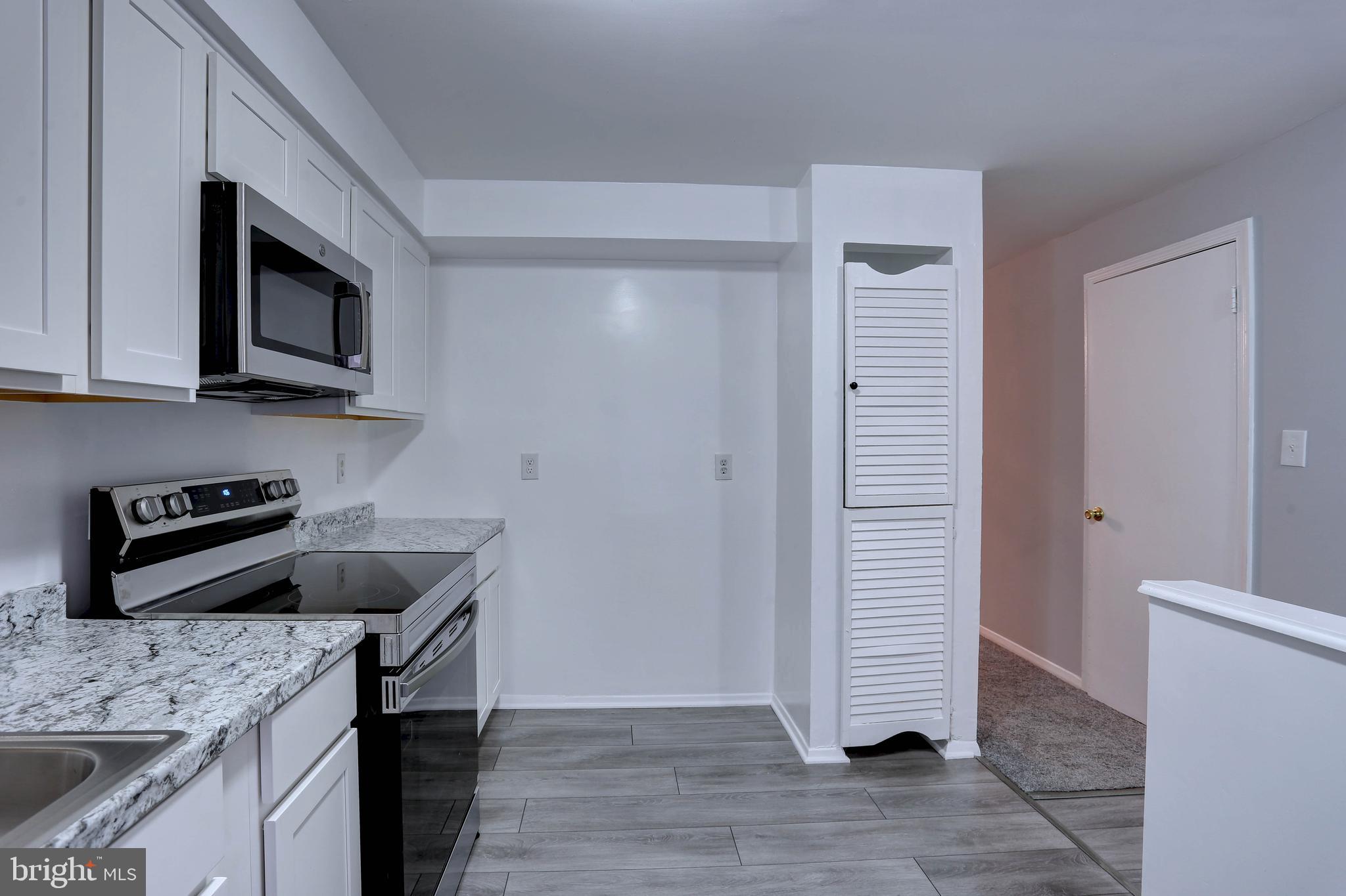 410 South Washington Street Baltimore, MD 21231 - Photo 5 of 29 a kitchen with stainless steel appliances granite countertop a stove microwave and sink