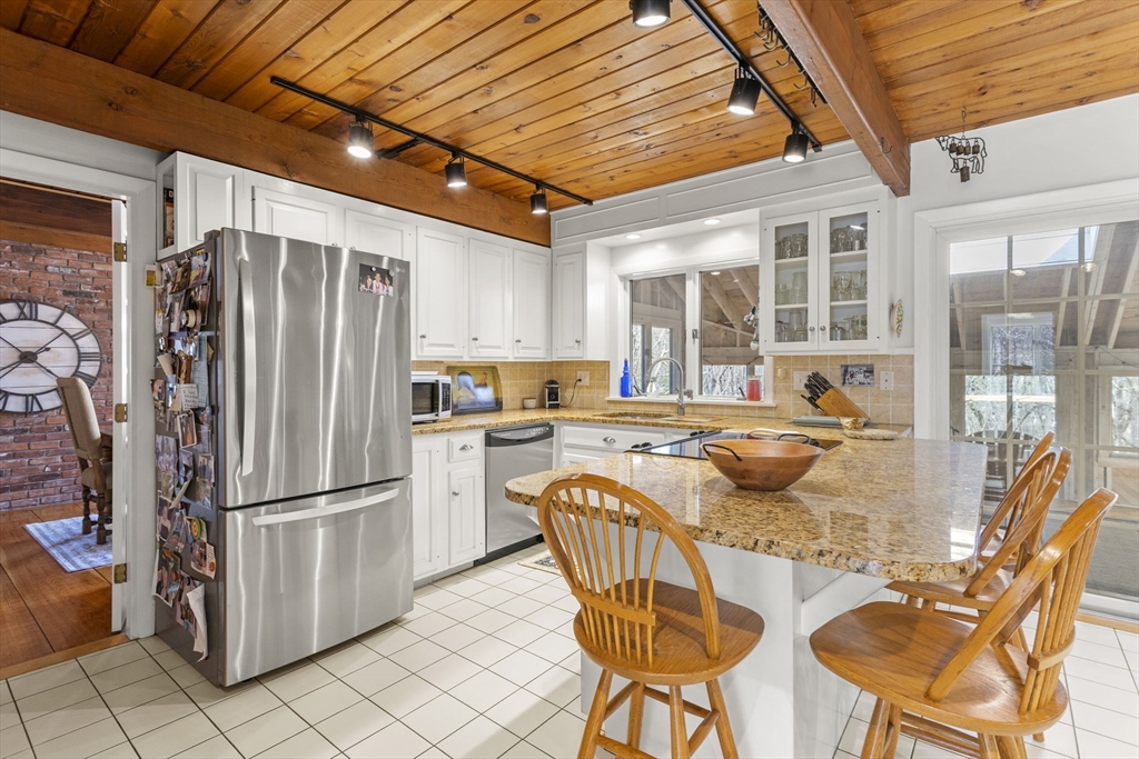 92 Middleton Road Boxford, MA 01921 - Photo 12 of 42 a kitchen with stainless steel appliances granite countertop a refrigerator and wooden cabinets