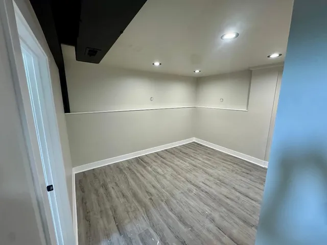 a view of empty room with wooden floor