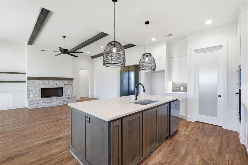 6412 Rigel Road Godley, TX 76044 - Photo 15 of 38 a kitchen with a sink a fireplace and wooden floor