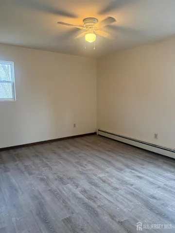 a view of an empty room and chandelier fan
