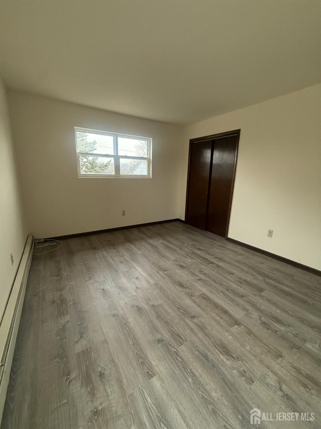 710-712 Drake Avenue, Unit 710 Middlesex, NJ 08846 - Photo 12 of 25 an empty room with wooden floor closet and windows