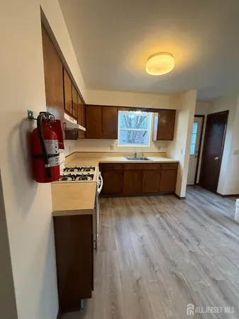 a kitchen with stainless steel appliances granite countertop a refrigerator a stove and a wooden floors