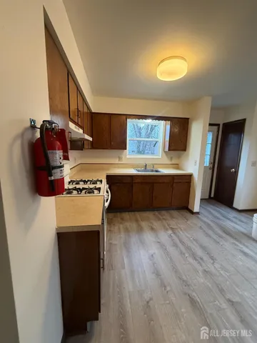 a kitchen with stainless steel appliances granite countertop a refrigerator a stove and a wooden floors