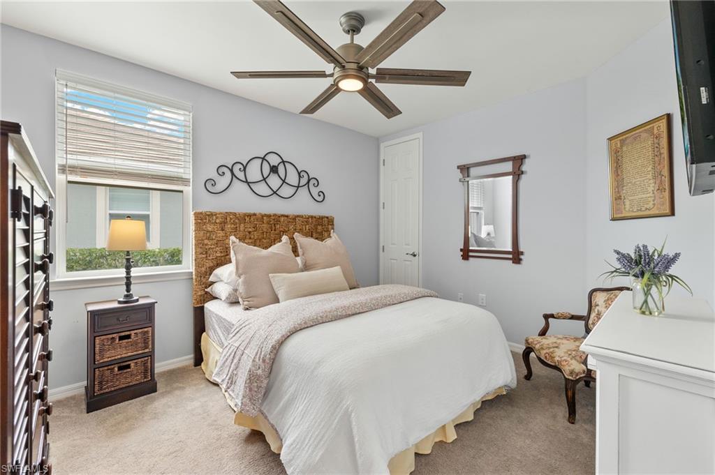 14615 Edgewater Circle Naples, FL 34114 - Photo 18 of 42 a bedroom with a bed and a chandelier