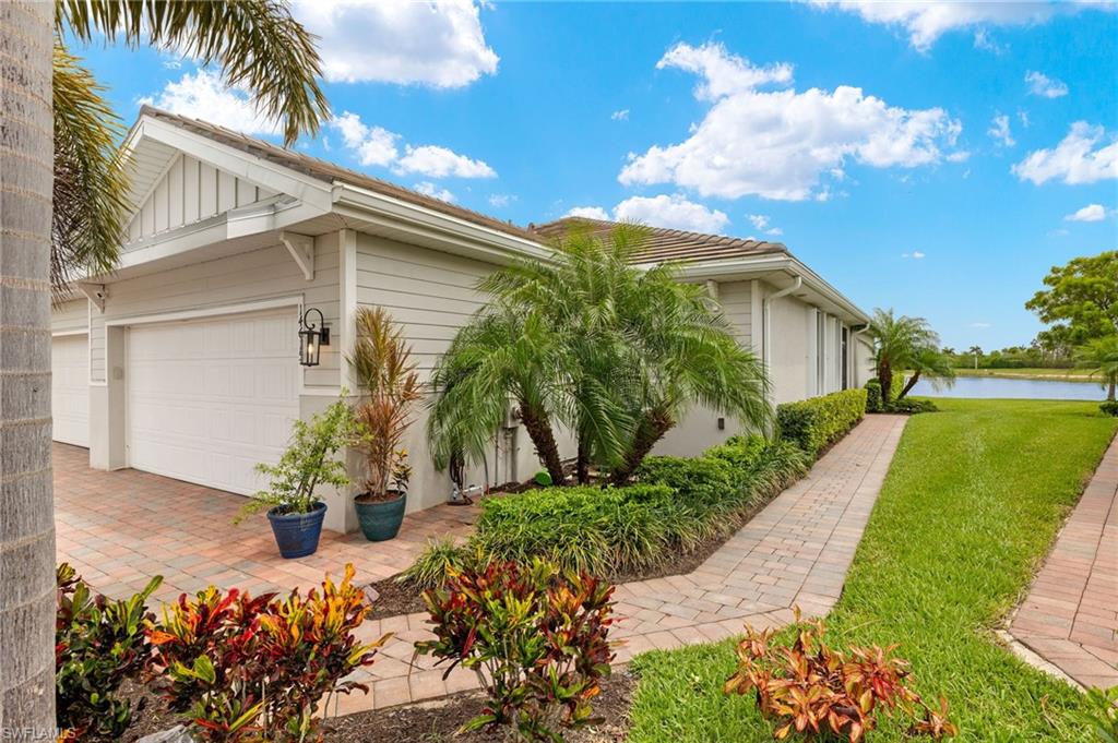 14615 Edgewater Circle Naples, FL 34114 - Photo 2 of 42 a front view of a house with a yard