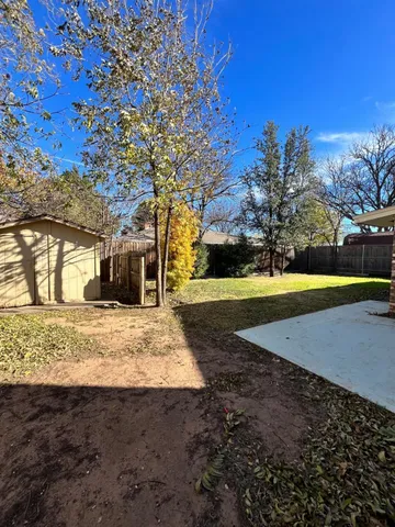 a view of a yard with a house and a large tree