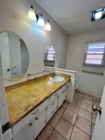 a bathroom with a granite countertop sink a mirror and a vanity