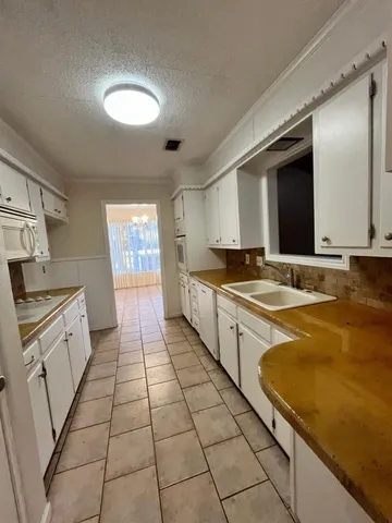 a large kitchen with stainless steel appliances granite countertop a sink and cabinets