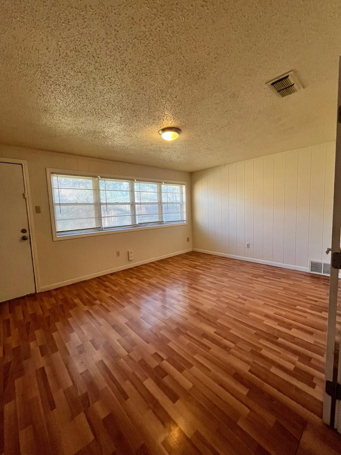 6305 Raleigh Avenue Lubbock, TX 79414 - Photo 10 of 19 an empty room with wooden floor and windows