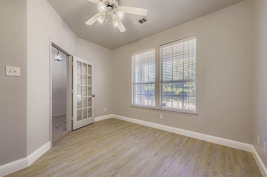4201 Broken Bend Boulevard Fort Worth, TX 76244 - Photo 14 of 34 an empty room with wooden floor chandelier fan and windows