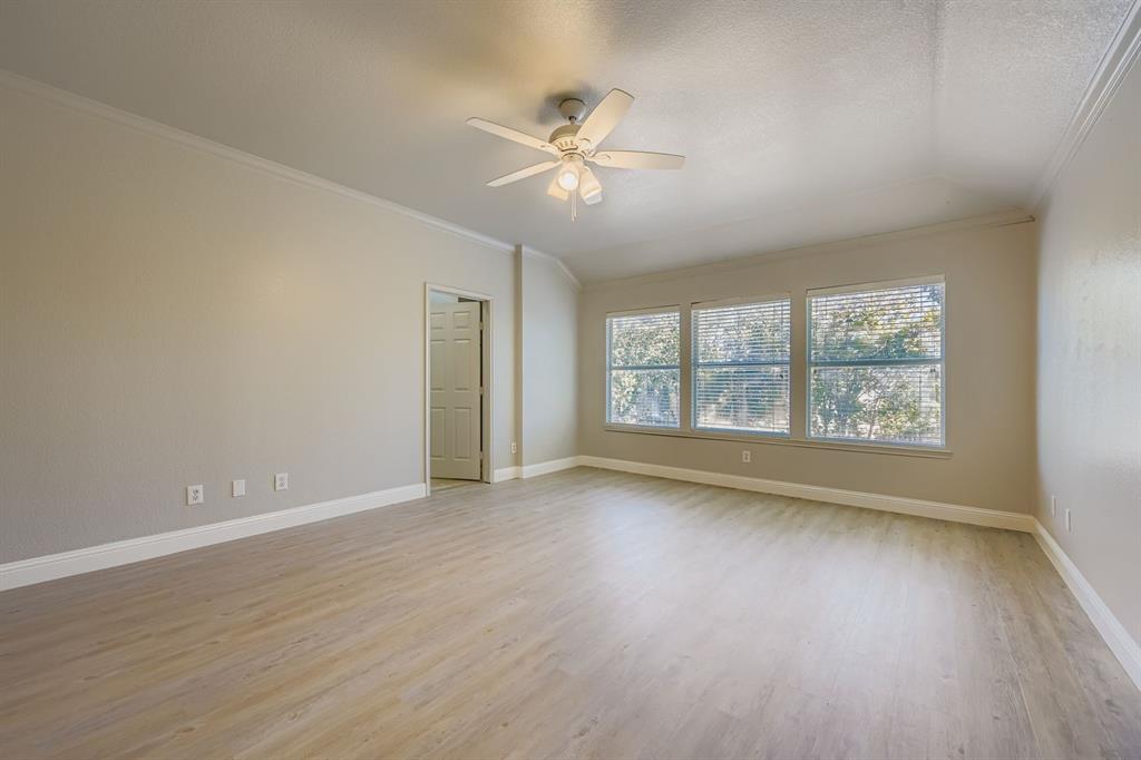 4201 Broken Bend Boulevard Fort Worth, TX 76244 - Photo 15 of 34 an empty room with wooden floor chandelier fan and windows