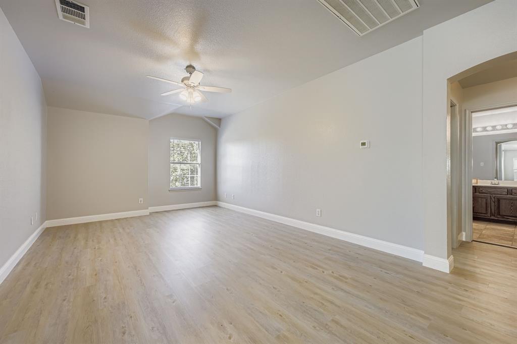 4201 Broken Bend Boulevard Fort Worth, TX 76244 - Photo 24 of 34 an empty room with wooden floor ceiling fan and windows