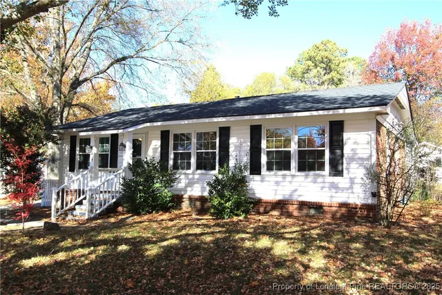 a front view of a house with a yard and potted plants