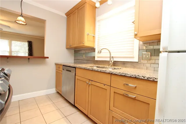 a kitchen with granite countertop a sink a stove and cabinets