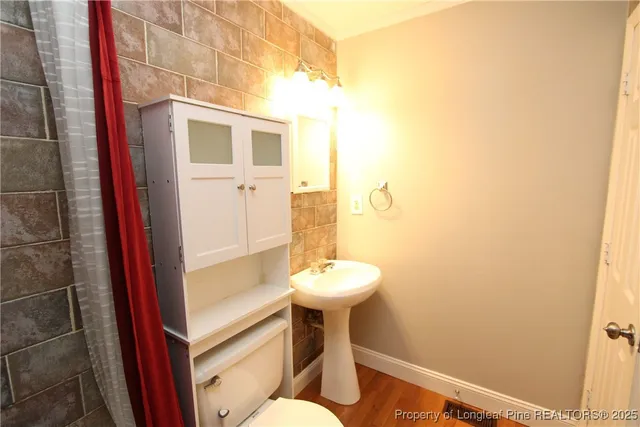 a bathroom with a sink mirror and toilet
