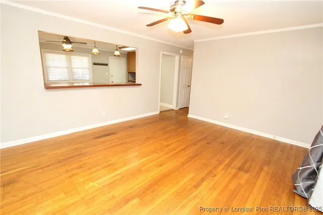 a view of a room with wooden floor and a ceiling fan